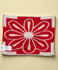 Red and beige knitted blanket with a floral pattern on a white background