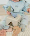 Child playing with wooden blocks on a soft surface